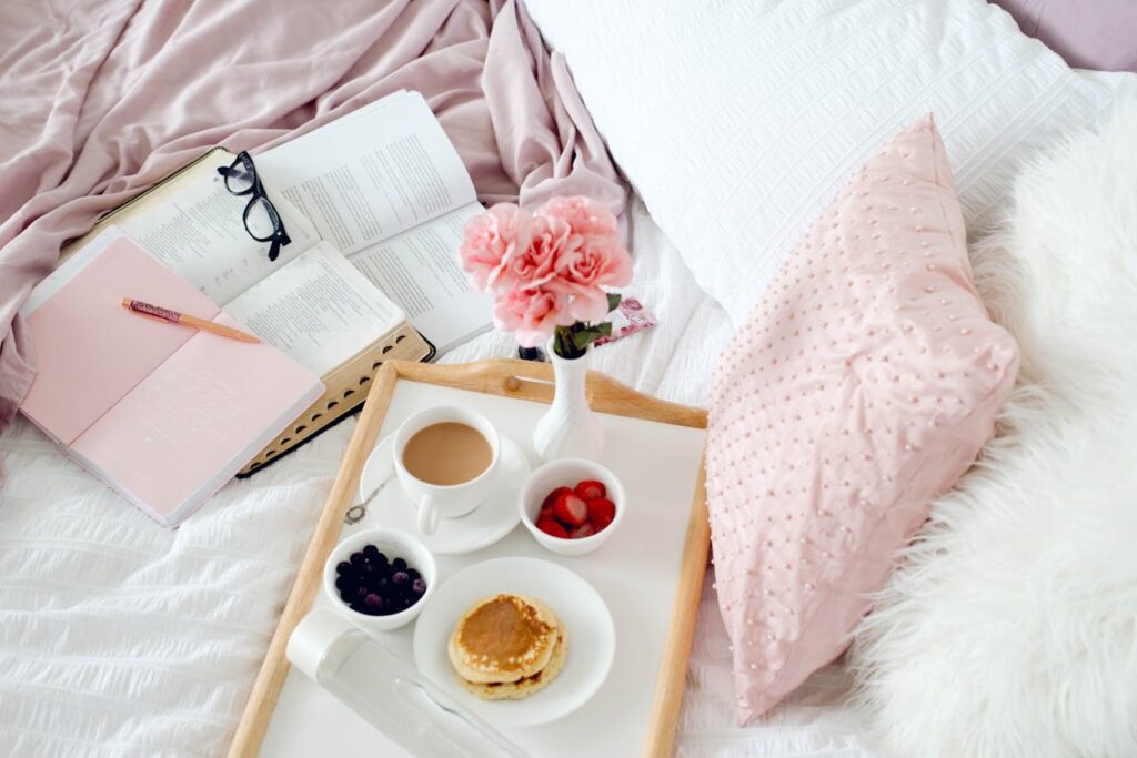 Inviting breakfast in bed scene with coffee, pancakes, and blooms, perfect for cozy mornings.